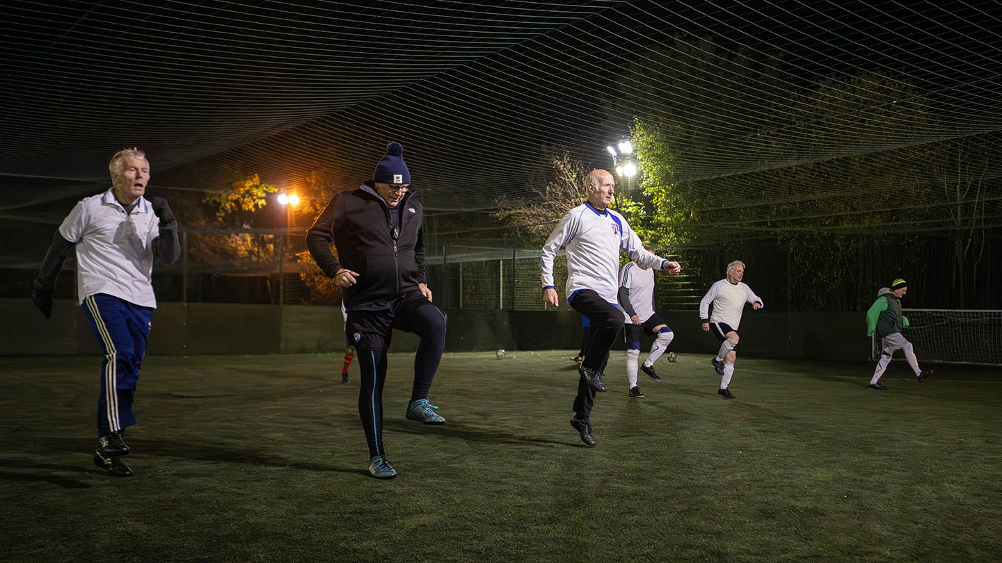 A nighttime image of Senior Spireites FC walking football team warming up pre-game.